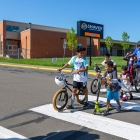 male with bike walking students with bikes across crosswalk