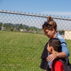 woman walking with arm around boy