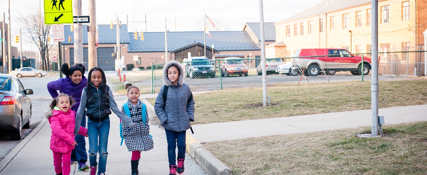 girls walking with sign behind